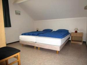 Un dormitorio con una cama con sábanas azules. en Bungalow in Breskens near Beach & Lighthouse, en Breskens 30 fotos más