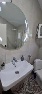 ein Badezimmer mit einem weißen Waschbecken und einem Spiegel in der Unterkunft Apartment Vujosevic D&D in Kotor
