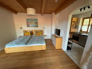 une petite chambre avec un lit et une cuisine dans l'établissement Bett & Berge - Ferienwohnung in den Schlierseer Bergen, à Schliersee