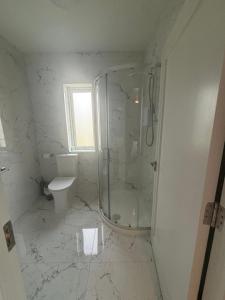 a white bathroom with a shower and a toilet at Independent Room Only - Listowel in Listowel