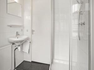 a white bathroom with a sink and a shower at Bungalow in South Holland with Private Jetty in Simonshaven +24 photos