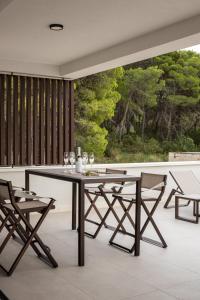 a dining room with a table and chairs on a balcony at Villa Remi in Sumartin