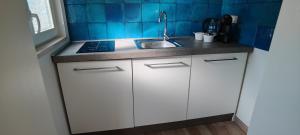 a small kitchen with white cabinets and a sink at Le casette in Monopoli
