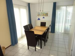 ein Esszimmer mit einem Holztisch und Stühlen in der Unterkunft Bungalow in Breskens near the Lighthouse in Breskens