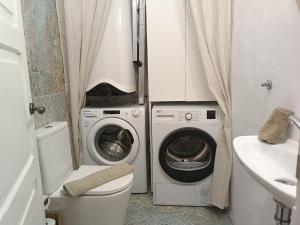 a bathroom with a washing machine and a washer and dryer at Casa Bailarina, romantický kamenný dům s úžasným výhledem na oceán in Agaete