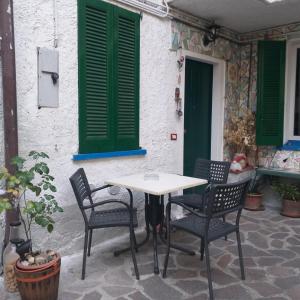 a table and chairs in front of a building with green shutters at B&B Mirna - Piccolo Appartamento in Vaprio dʼAdda +27 photos