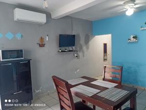 a dining room with a table and a tv on a wall at Casa sencilla, primer piso bien ubicada in Mazatlán
