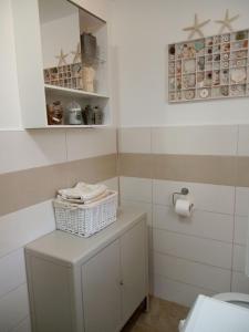 a bathroom with a toilet and a basket on a cabinet at House Paisley Dream in Ugljan