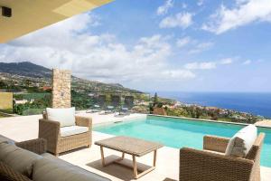 a swimming pool with a view of the ocean at Villa Ohana in Estreito da Calheta