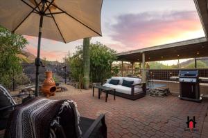 a patio with a couch and an umbrella at Sonoran Desert Getaway with Cowboy Tub in Cave Creek