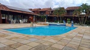 a swimming pool in front of a house at Casa Chalé com 3 quartos pra dez pessoas com piscina aquecida nos feriados in Gravatá