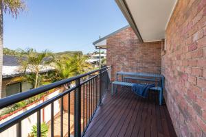 a blue bench sitting on a balcony at Beach Cockatoo 2Bed Steps from Sand, perfect surf getaway in Emerald Beach