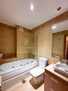 a bathroom with a tub and a toilet and a sink at Apartamento con garaje, céntrico y luminoso in Pontevedra