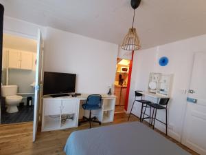 a bedroom with a bed and a desk with a television at Studette pour 1 ou 2 personnes in Chaumont