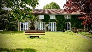 a bench sitting in front of a green house at Gîte Duplex Vallée de la Vienne in Availles-Limouzine