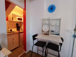 a small kitchen with a white table and chairs at Studette pour 1 ou 2 personnes in Chaumont