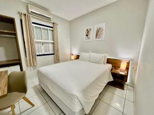 Un dormitorio con una gran cama blanca y una ventana. en Hotel Arrastão, en São Sebastião 43 fotos más