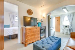 Una sala de estar con un televisor y un sofá azul. en Walk to Lake Erie Shore Quiet Getaway with Fire Pit, en Irving