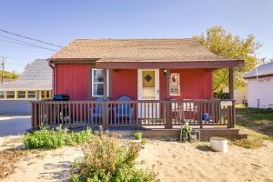 una casa roja con 2 sillas en un porche en Walk to Lake Erie Shore Quiet Getaway with Fire Pit, en Irving