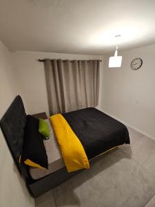 a bedroom with a bed with yellow and black pillows at Spacious, cozy double room 3 with amenities in Nottingham