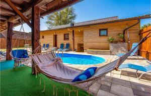 TounjにあるBeautiful Home In Tounj With Wifiのプール付きの家の前のハンモック