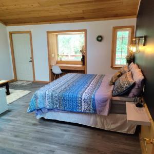 a bedroom with a bed with a blue comforter at Hummingbird B&B in Gabriola +36 photos