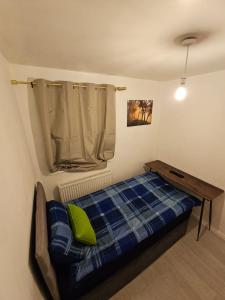 a small bedroom with a bed and a table at Spacious single room in Nottingham