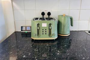 a green toaster sitting on top of a counter at Bella Homes-Spacious 4 bedroom Modern Town house Romford in Romford