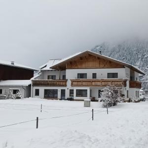 een groot gebouw met sneeuw op de grond bij Landhaus Zell in Längenfeld