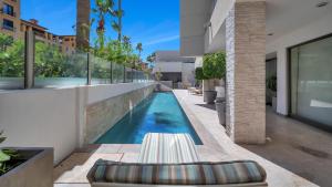 a swimming pool in front of a building with a house at One Medano 8B in Cabo San Lucas