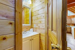 un baño con lavabo y espejo en Sugar Bear Cabin, en Sevierville 17 fotos más
