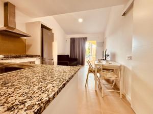 une cuisine avec un comptoir et une table avec des chaises dans l'établissement Click&Guest - Golden Sands in Maspalomas, à San Fernando