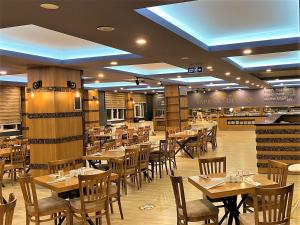 een eetkamer met houten tafels en stoelen bij Sapran Deluxe Hotel in Kars