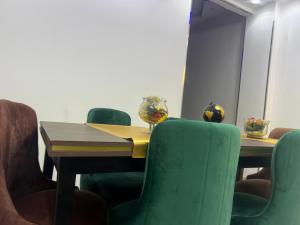 a conference room with a wooden table and green chairs at Pyramid Heights Apartments in Cairo