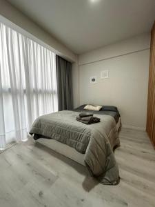 ein Schlafzimmer mit einem Bett und einem großen Fenster in der Unterkunft Departamento Flores in Buenos Aires