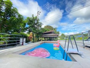 a pool with two inflatable flamingos and a slide at De'Sister Pool Villa Hatyai in Ban Tha Nang Hom (1)