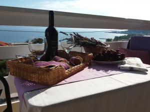 a table with two baskets of grapes and a bottle of wine at Apartments Boro in Dugi Rat +40 photos