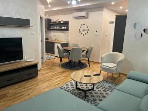a living room with a couch and a table and chairs at CENTRAL SQUARE - Apartmani Centar Zlatibor in Zlatibor