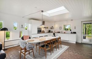 a kitchen and dining room with a table and chairs at Three-Bedroom Holiday Home Thyholm With A Fireplace 06 in Sønder Ydby +14 photos