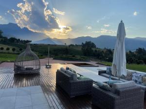 a patio with two couches and an umbrella at Champagne Manor in Mountain Herberg Hostel