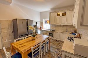 a kitchen with a wooden table and a refrigerator at Poarta Maramureșana Borșa Complex in Statiunea Borsa +44 photos