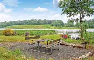 a picnic table and a bench next to a lake at Holiday Home Koldingvej in Almind