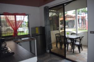 a kitchen and dining room with a table and chairs at Apartahotel El Padrino in Puerto Jiménez