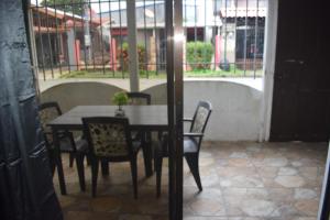 a table and chairs in a room with a window at Apartahotel El Padrino in Puerto Jiménez +3 photos
