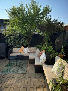 a patio with couches and a table and trees at Milan Casa in Winnersh