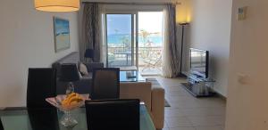 ein Wohnzimmer mit einem Esstisch und einem TV in der Unterkunft El Kheima Beach Resort in Sharm El Sheikh