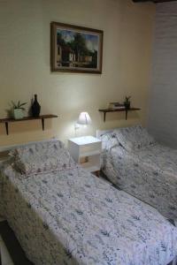 - une chambre avec 2 lits et une table avec une table de chevet dans l'établissement Cabaña en el Pedemonte, à Luján de Cuyo