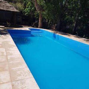 une grande piscine bleue dans une cour dans l'établissement Cabaña en el Pedemonte, à Luján de Cuyo