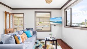a living room with a blue couch and a window at Lionel Gem in Shoal Bay