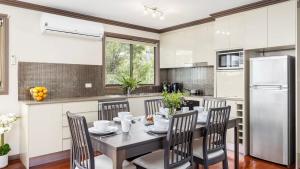 a kitchen with a table and chairs and a refrigerator at Lionel Gem in Shoal Bay